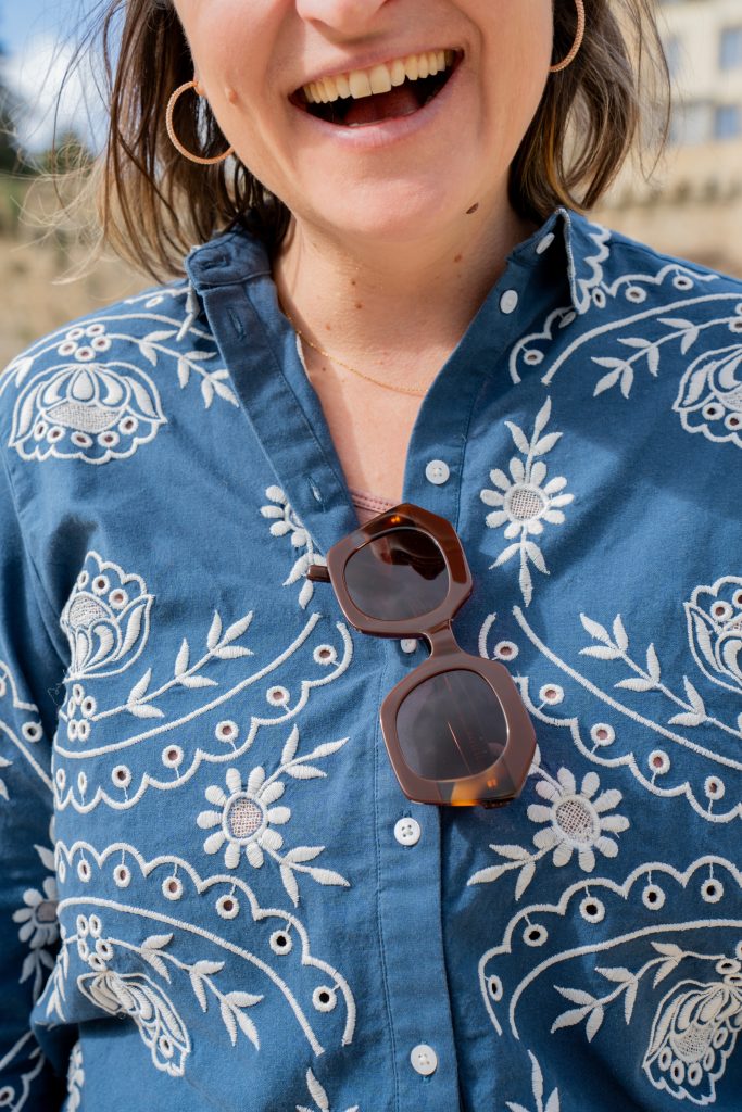 l'opticienne sourit et porte ses solaires sur sa chemise